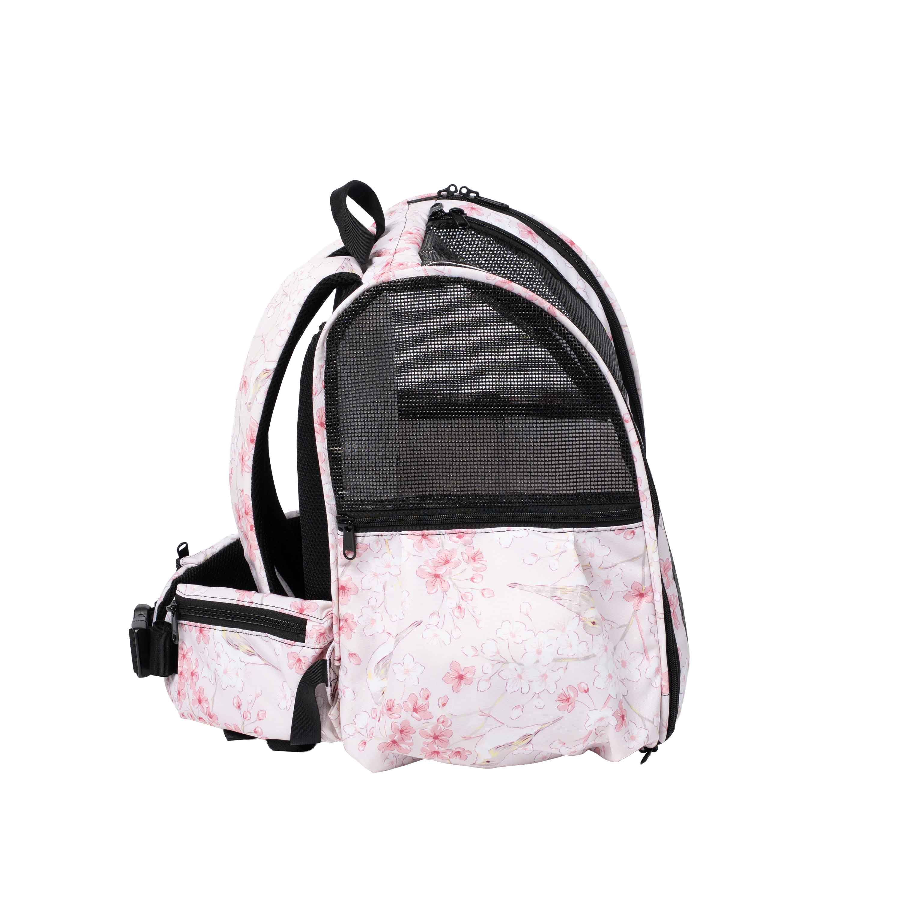 Pink pet backpack with a delicate floral print, black mesh panels, and adjustable straps.