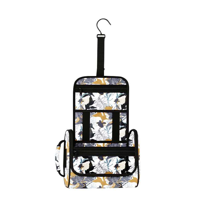 Midnight Bloom hanging toiletry bag with white, gold, gray, and blue floral pattern, black zippers, and hook.