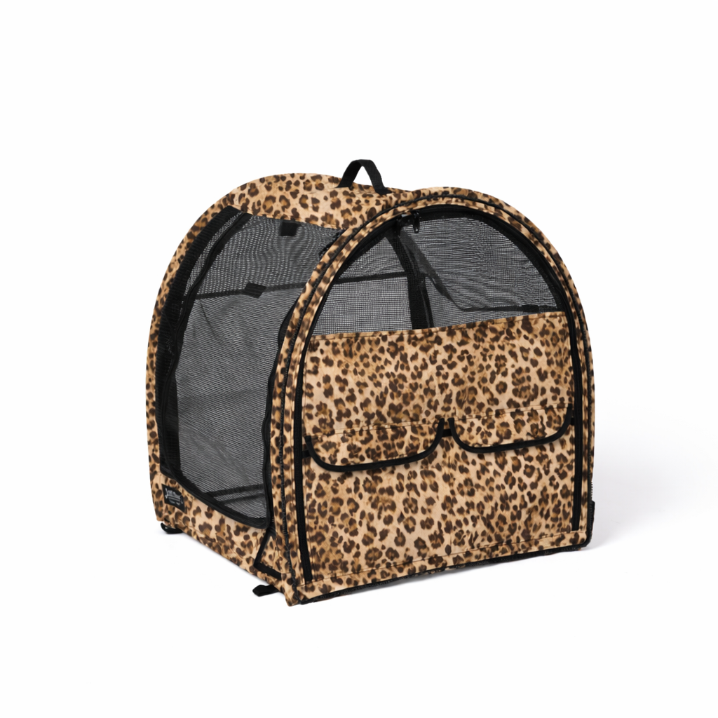 Leopard print modular portable pop-up pet kennel with mesh doors and storage pockets on a white background.