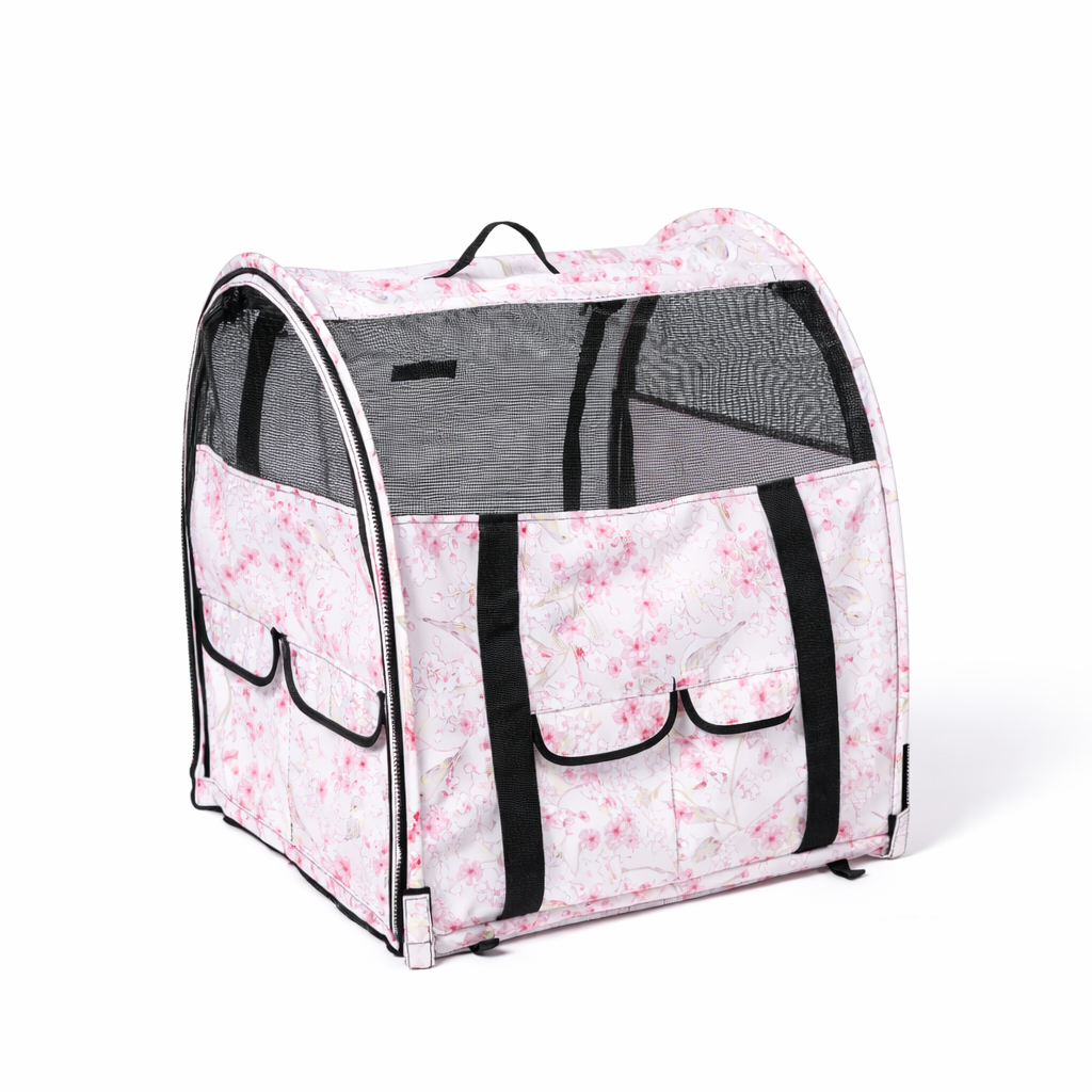Pink floral pop-up pet kennel with black mesh windows, carrying straps, and exterior pockets.