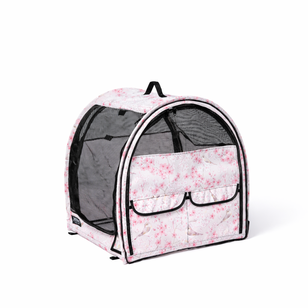 Pink cherry blossom patterned modular pop-up pet kennel with mesh doors, black trim, and front storage pockets.