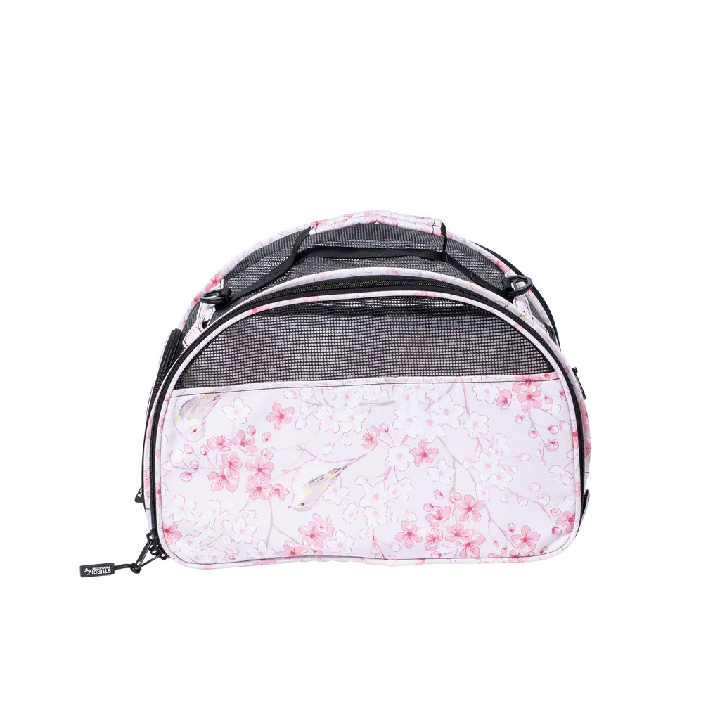 Pink floral pet carrier with black mesh panels and top handle.