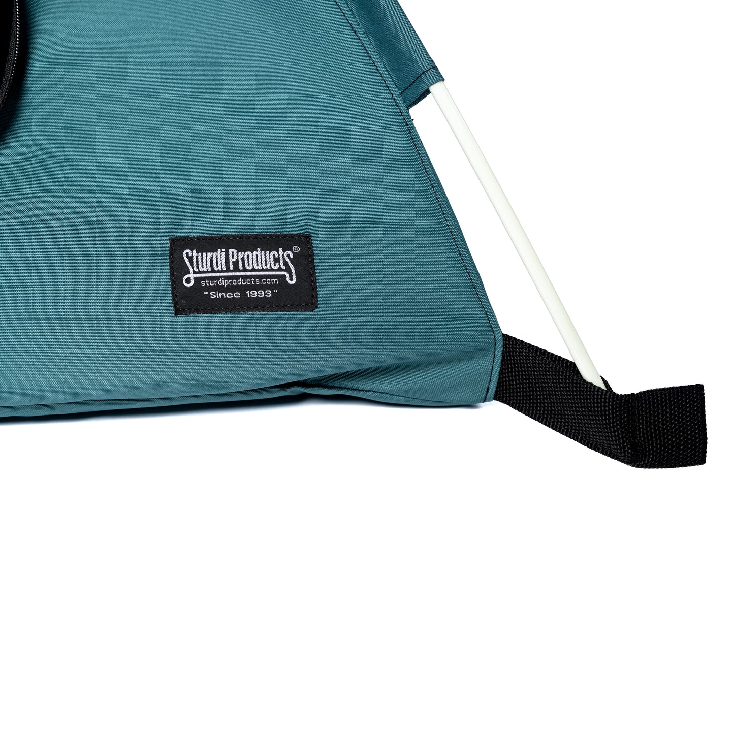 Close-up of a teal 600D polyester Sturdi Products pop-up pet tent with a black logo patch and white pole.