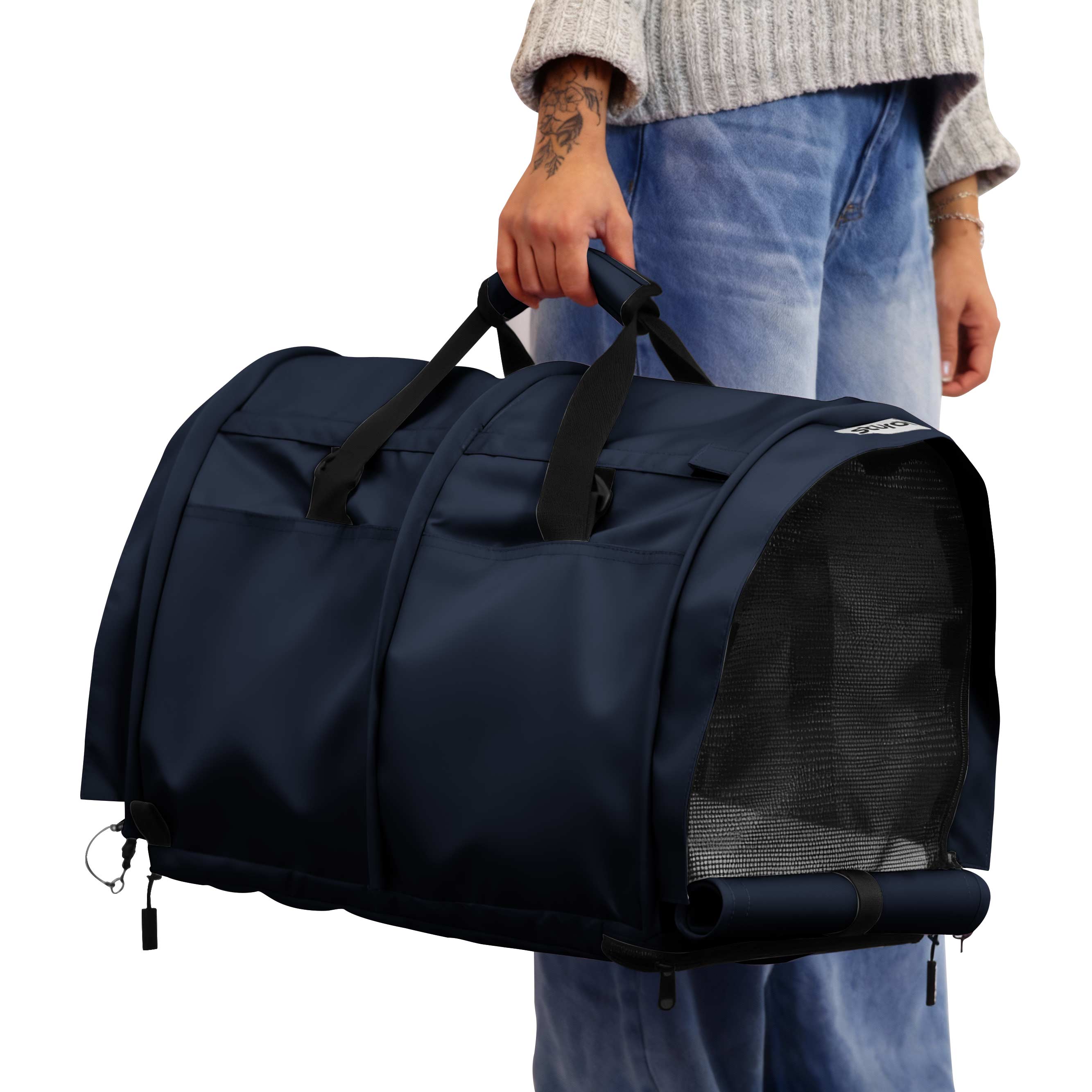 Person holding a navy blue SturdiBag Pro 3.0 divided pet carrier with mesh panels and top handles.