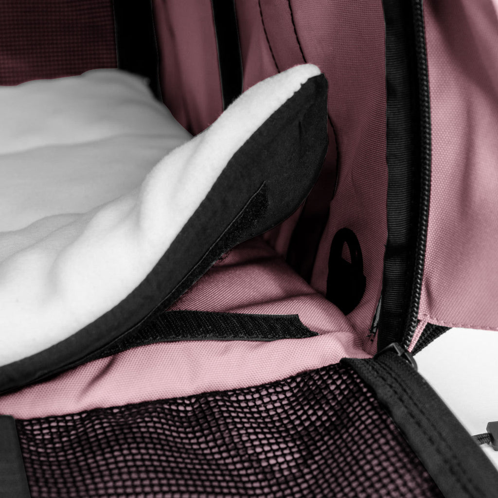 Pink SturdiBag Pro 3.0 pet carrier interior with white fleece pad, black mesh, and zipper detail.