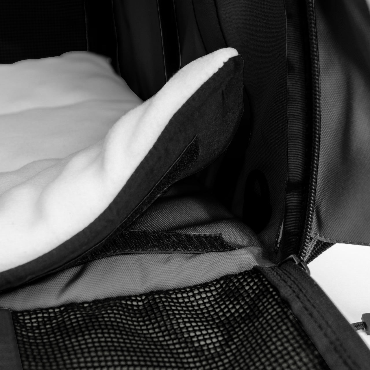 Black SturdiBag Pro 3.0 pet carrier interior with a white fleece comfort pad and mesh panel.