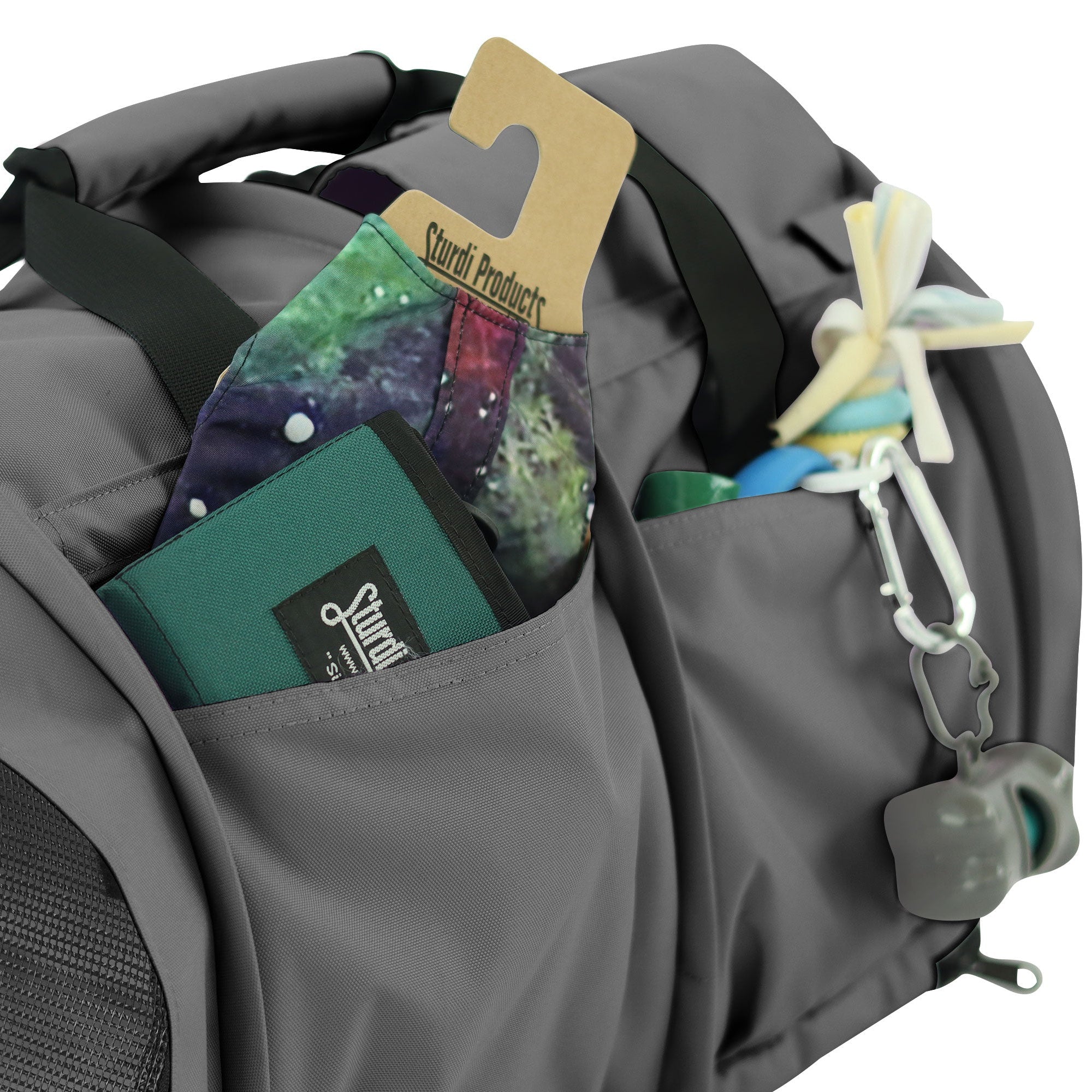 Gray SturdiBag Pro 3.0 pet carrier with side pockets holding accessories and a toy.