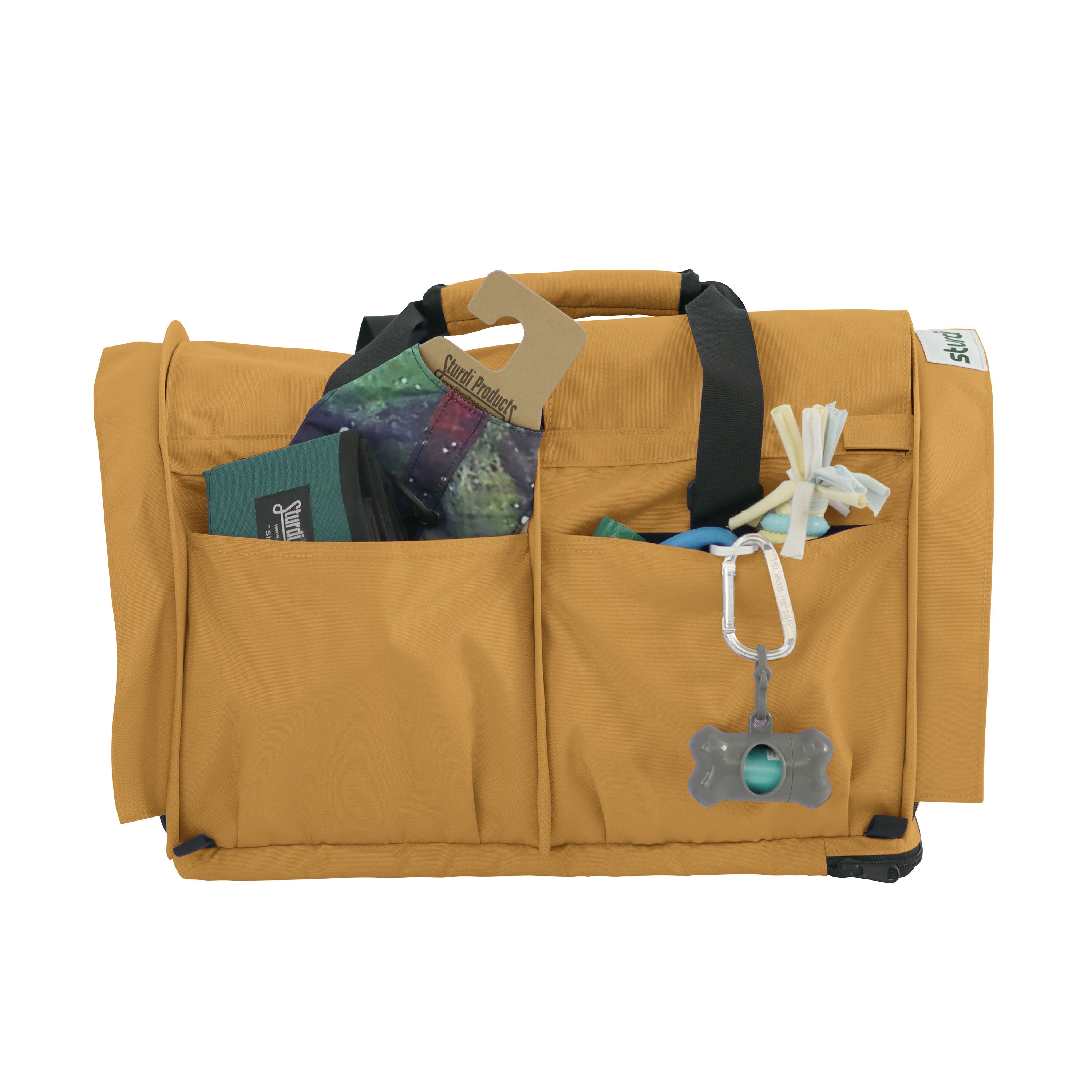 Tan SturdiBag Pro 3.0 pet carrier with front pockets holding pet essentials and a carabiner.
