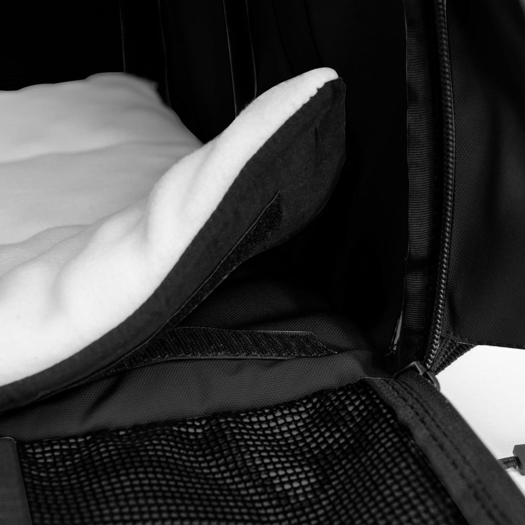 Black SturdiBag Pro 3.0 pet carrier interior with a soft white fleece comfort pad and mesh pocket.
