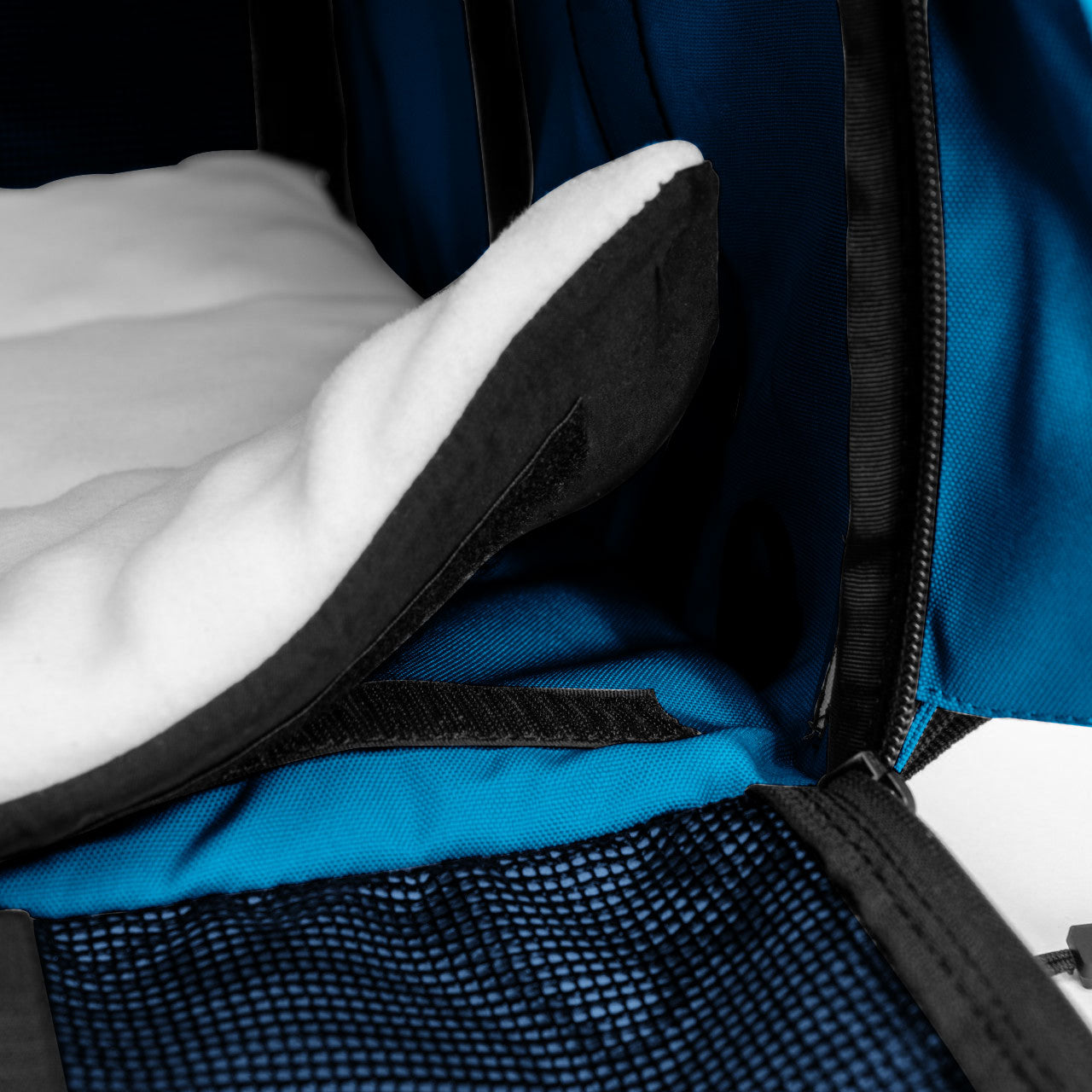 Close-up of a blue SturdiBag Pro 3.0 pet carrier interior with a white fleece comfort pad and mesh pocket.