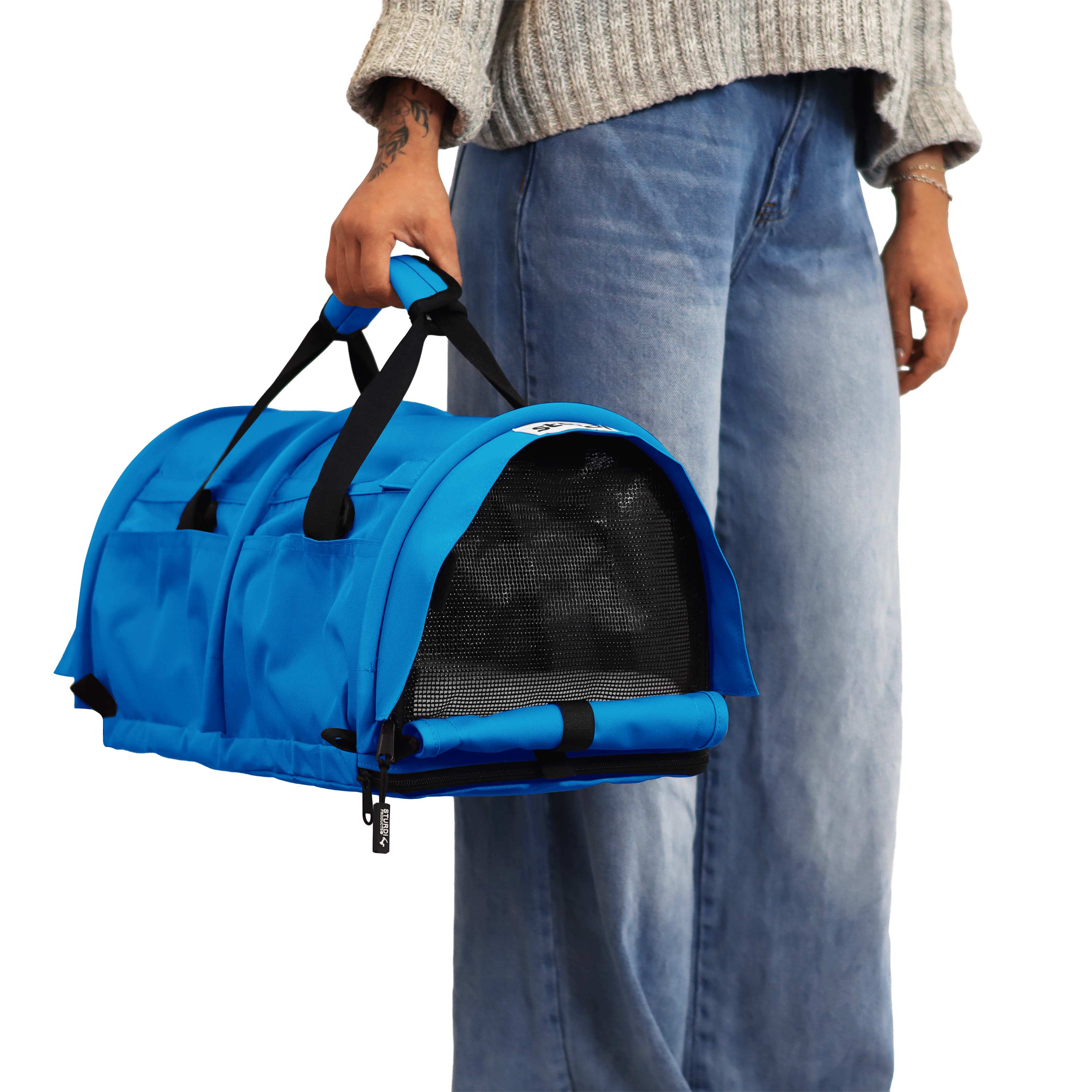Person holding a bright blue SturdiBag Pro 3.0 pet carrier with black mesh panels and handles.