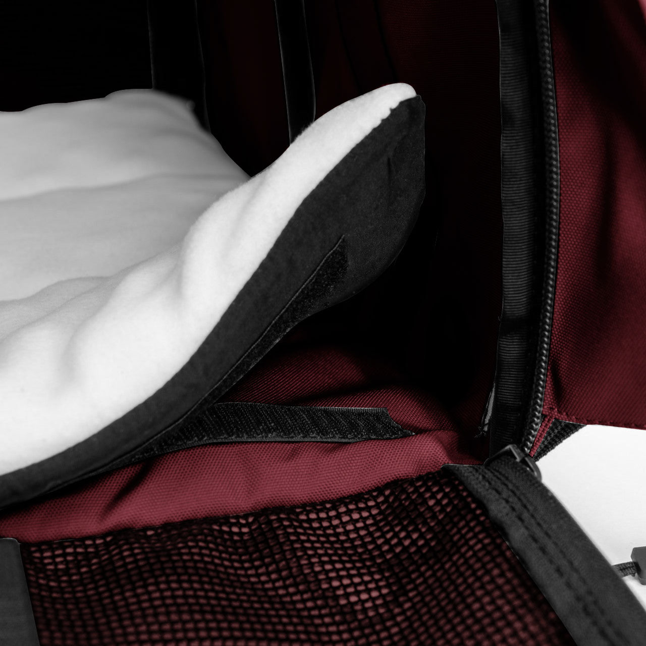 Close-up of a maroon SturdiBag Pro 3.0 pet carrier interior with a white fleece pad and mesh pocket.