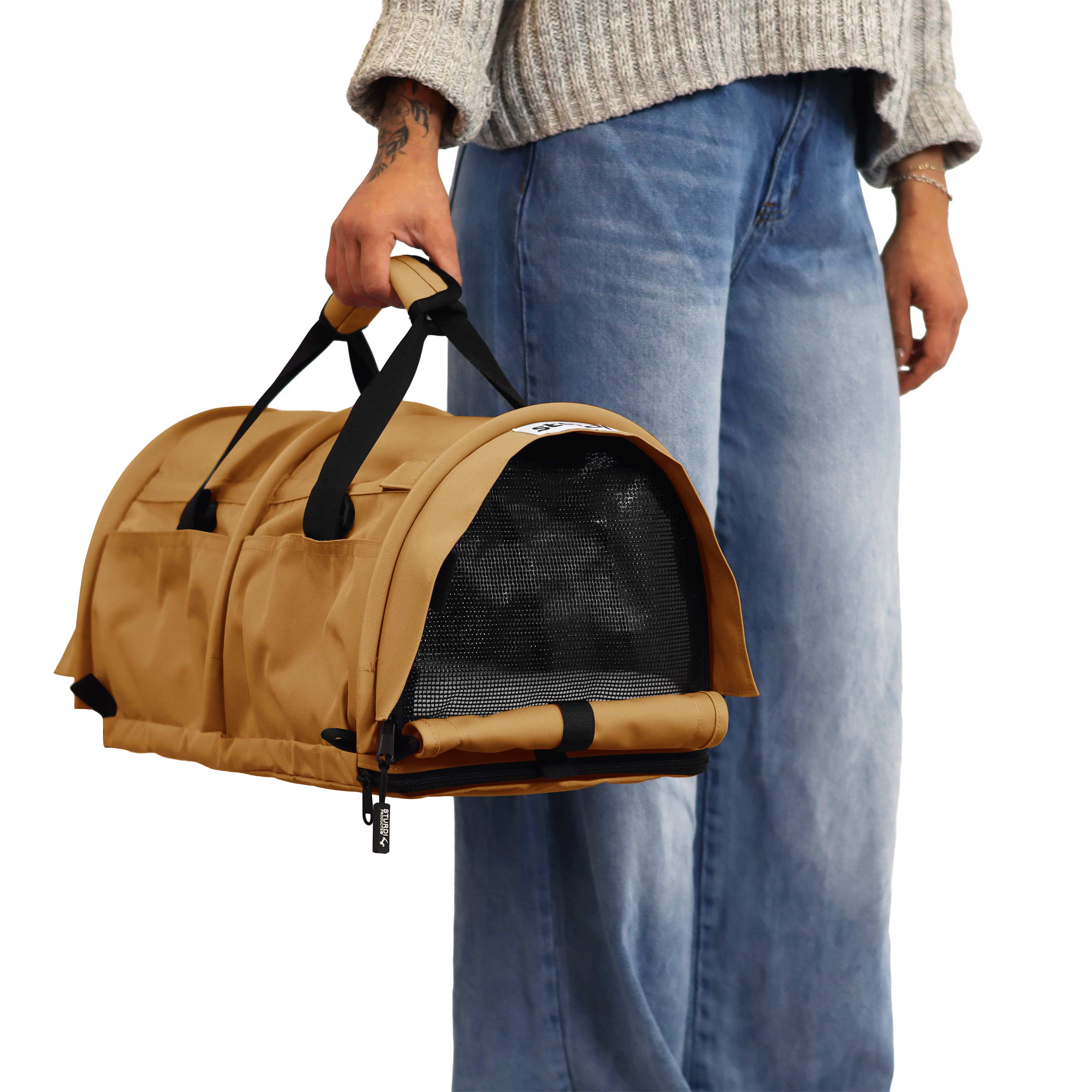 Tan SturdiBag Pro 3.0 pet carrier with mesh window, held by a person in jeans.