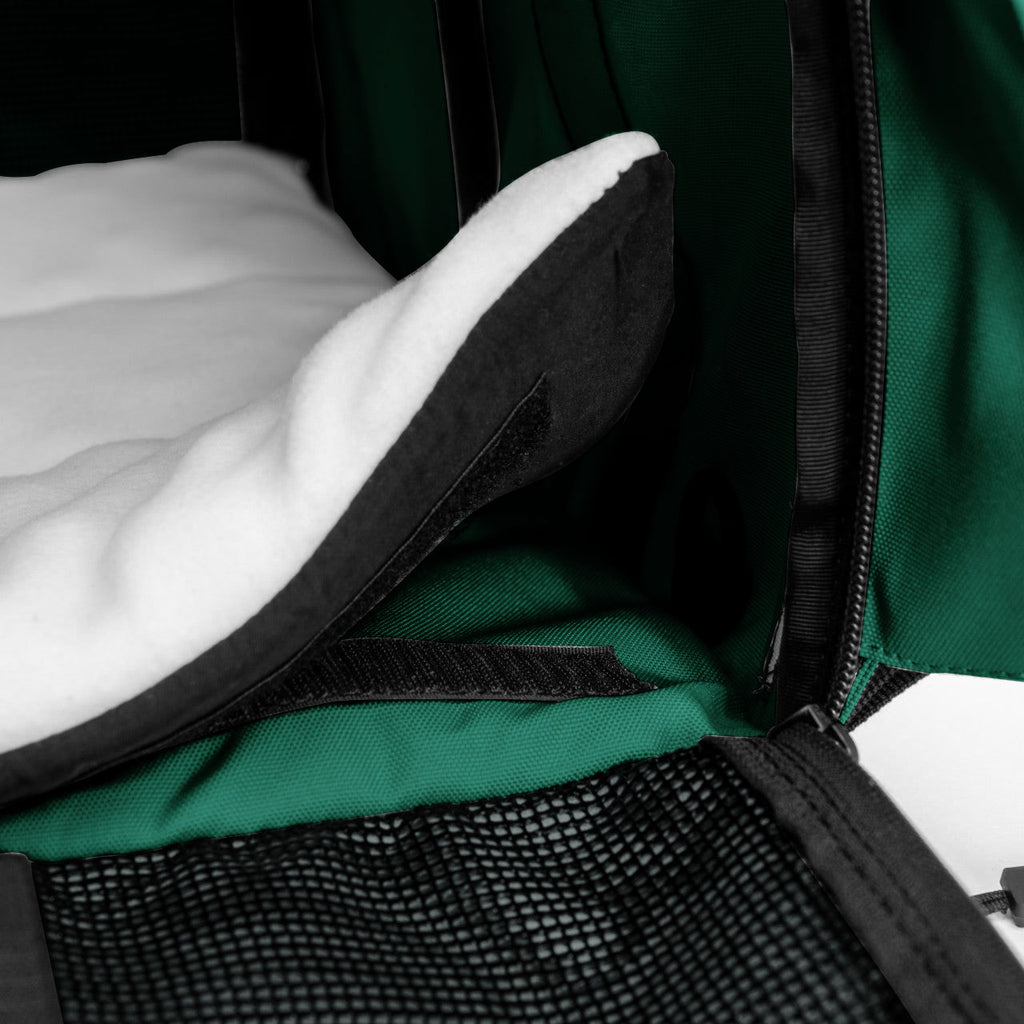 Close-up of a green SturdiBag Pro 3.0 pet carrier interior with a soft white fleece pad and mesh panel.