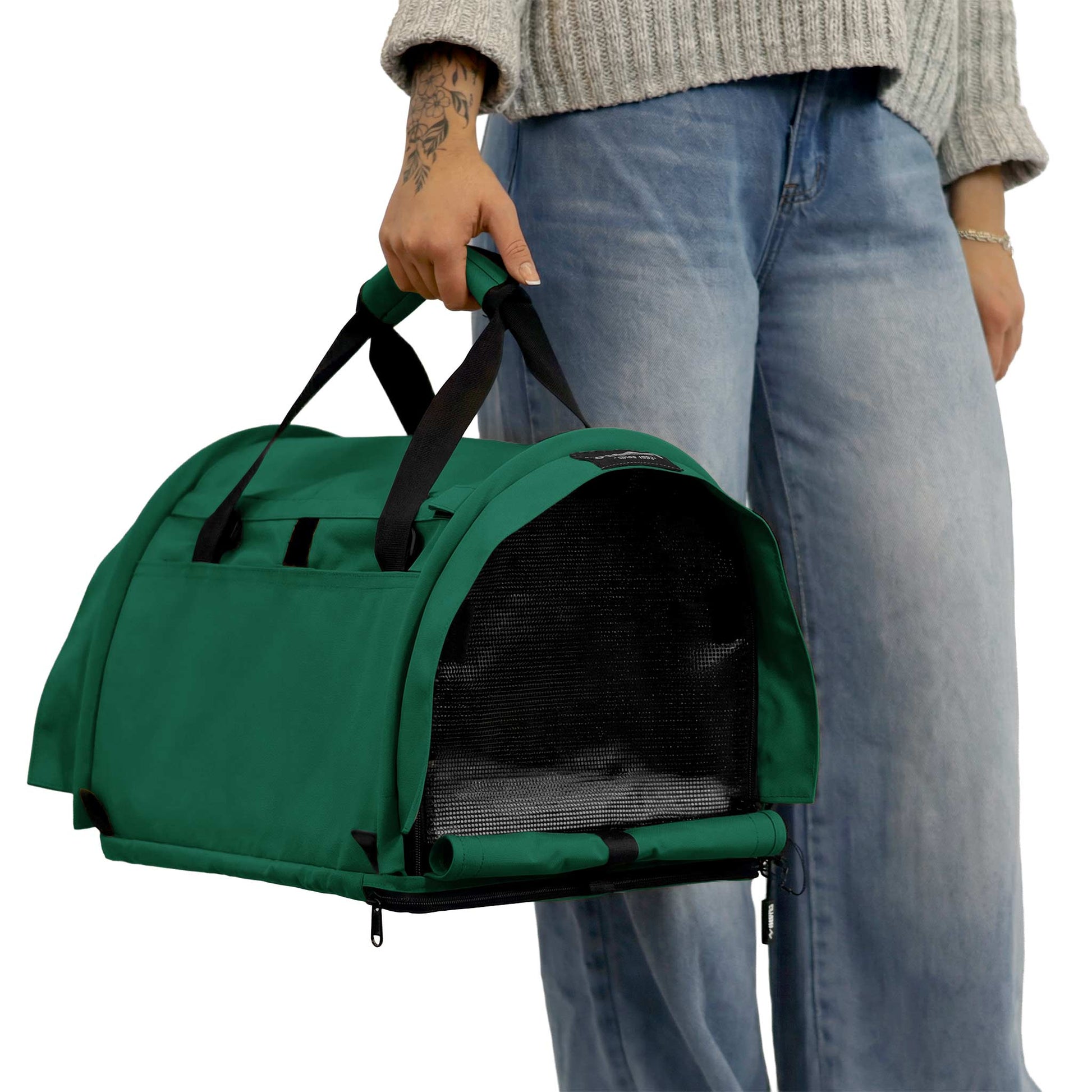 Person holding a green SturdiBag Pro 3.0 soft-sided pet carrier with mesh window and black straps.