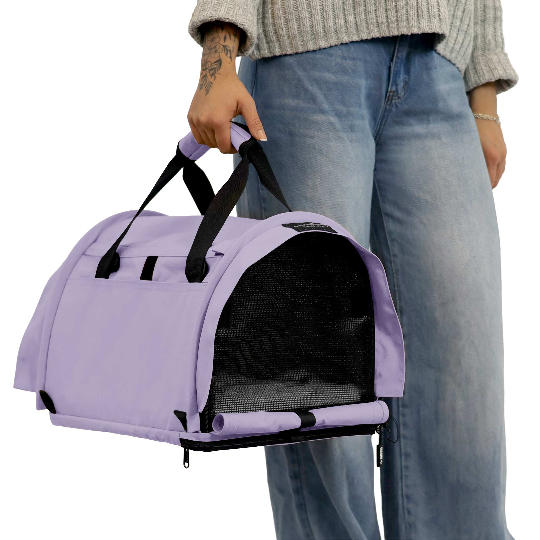Lavender SturdiBag Pro 3.0 soft-sided pet carrier with black mesh panels and straps, held by a person.