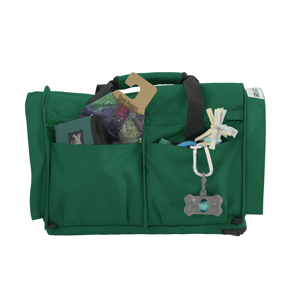 Green SturdiBag Pro 3.0 pet carrier with front pockets holding pet essentials, handles, and shoulder strap.