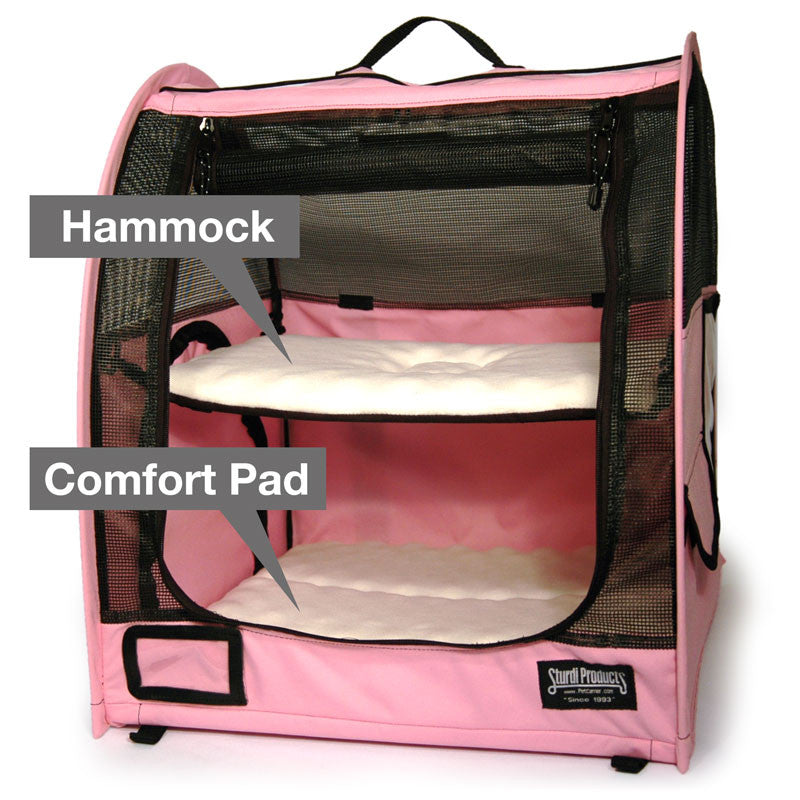 Pink pop-up pet kennel with two white fleece comfort pads, one as a hammock, the other on the bottom.
