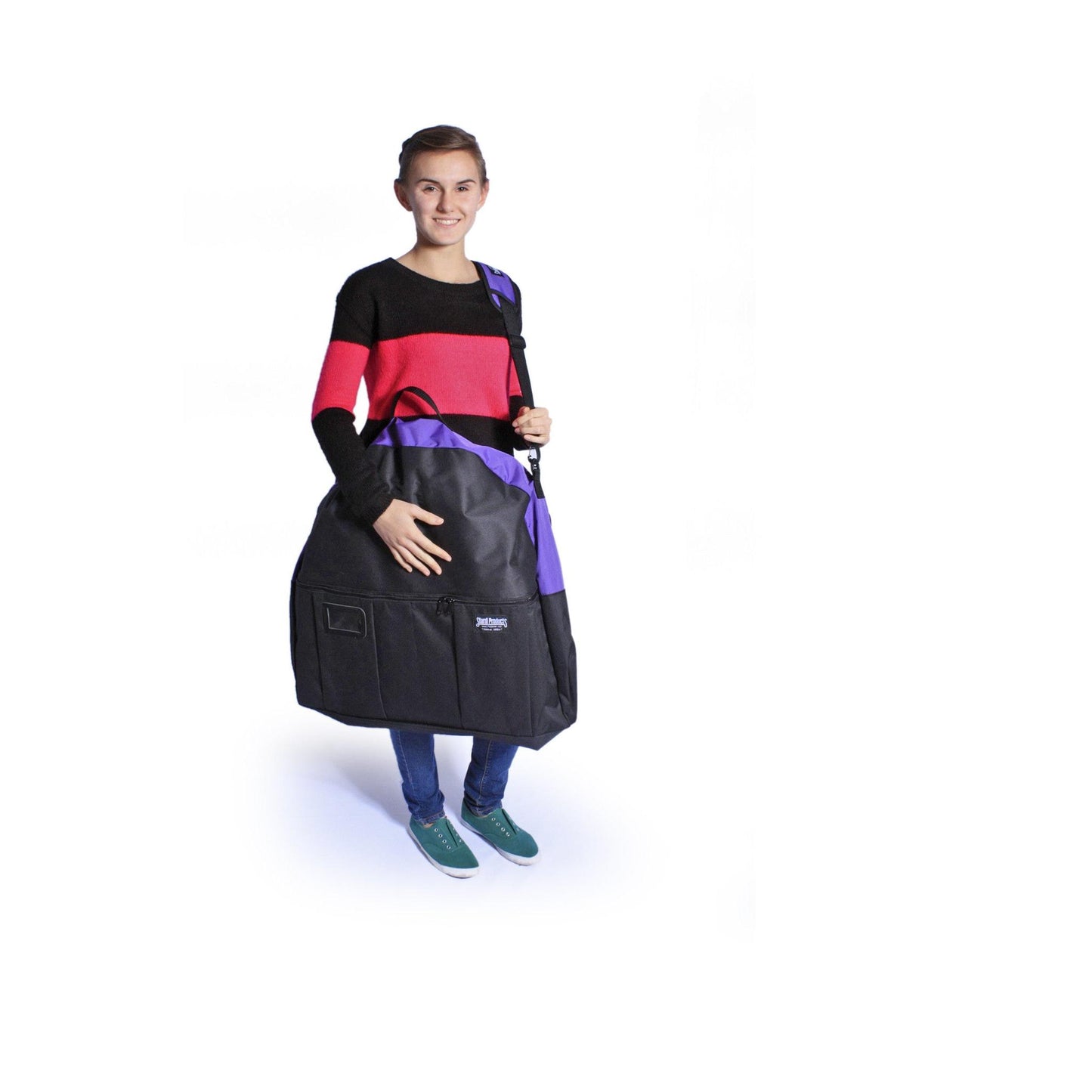 Woman holds a black and purple Sturdi Products carrying case for pop-up kennels, featuring a shoulder strap.